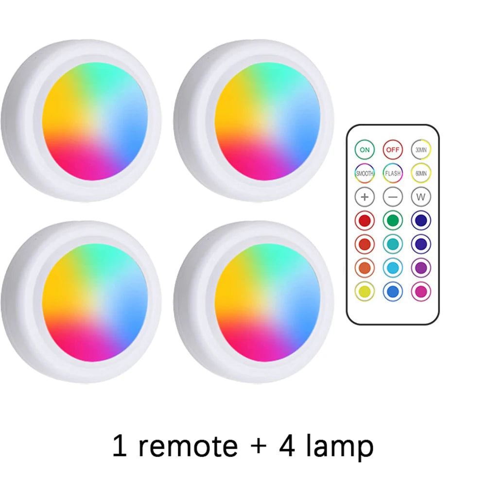 Four RGB LED lights with a remote control on a white background