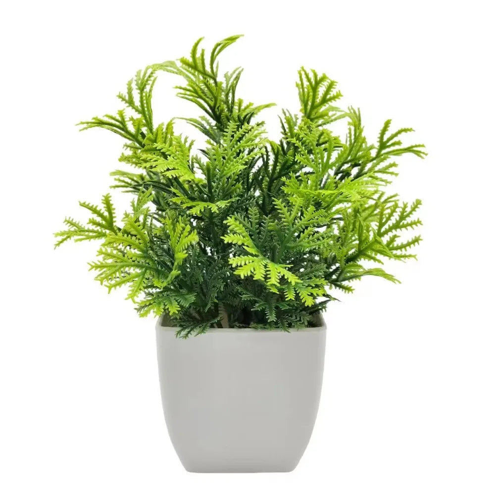 Small artificial potted plant with green foliage in a white pot, view 2