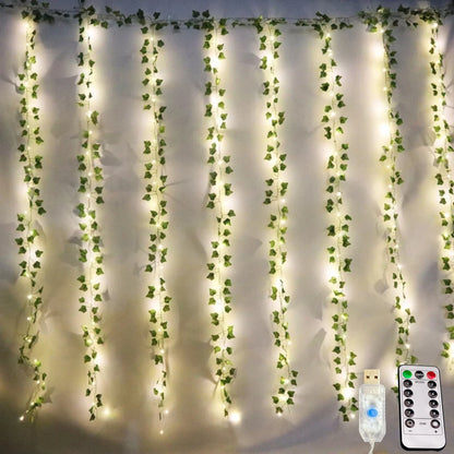 Artificial ivy garland string lights lit behind a bed
