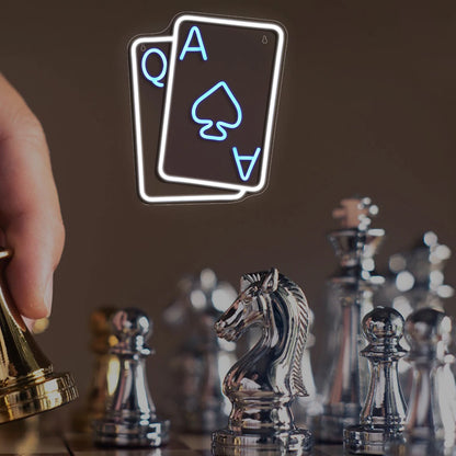 Neon sign of playing cards above a chessboard with chess pieces.