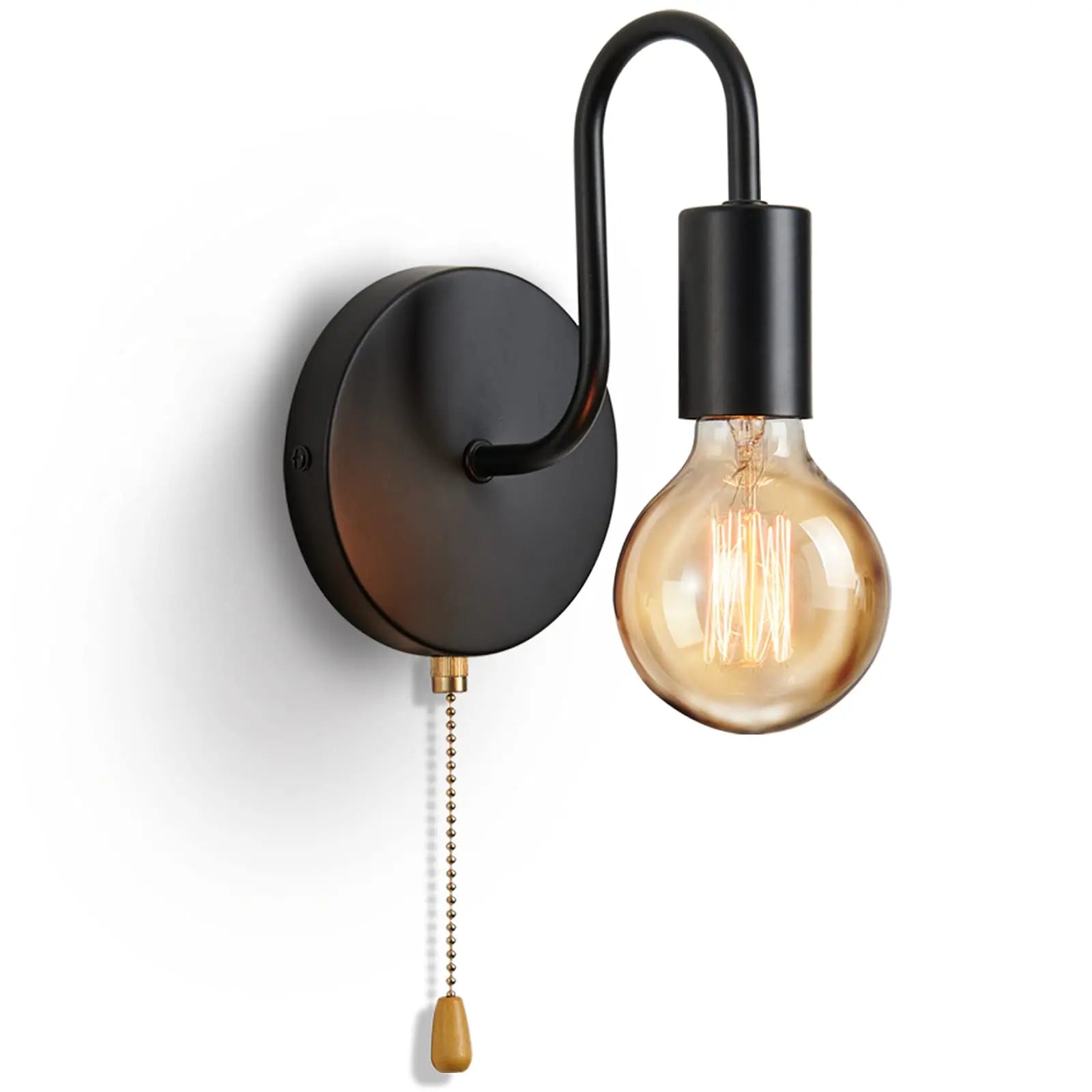 Black iron wall sconce mounted beside bed
