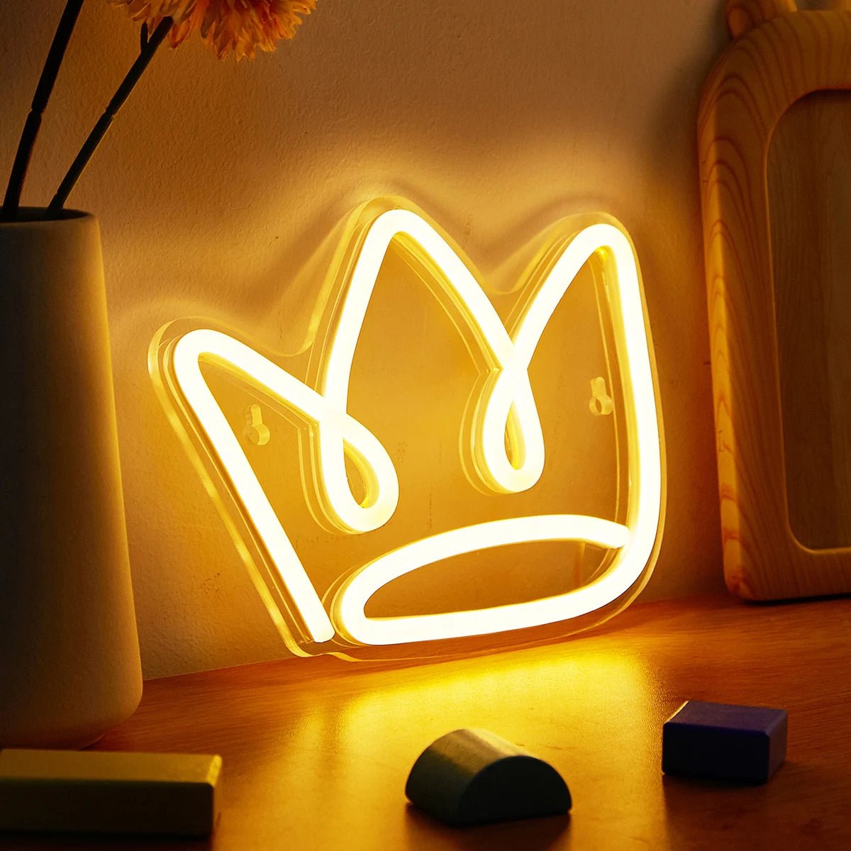 Neon crown light on a wooden surface with a soft focus background