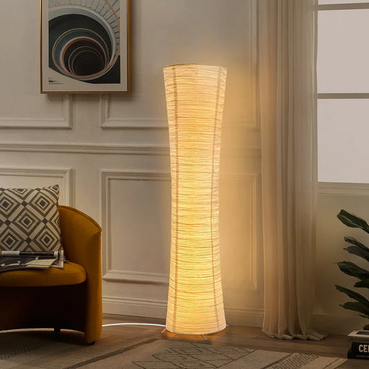 Floor lamp in a living room setting with a chair and artwork on the wall.