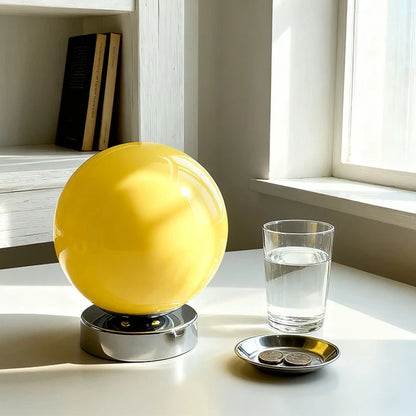 Orange glass sphere lamp on a wooden side table