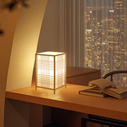 Bamboo bedside lamp casting a woven pattern on the wall