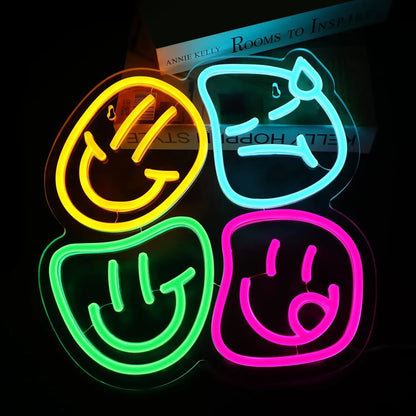 Four neon signs shaped like smiley faces in yellow, blue, green, and pink on a black background.