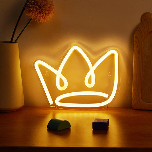Neon crown light on a wooden surface with a vase and decorative items in the background.