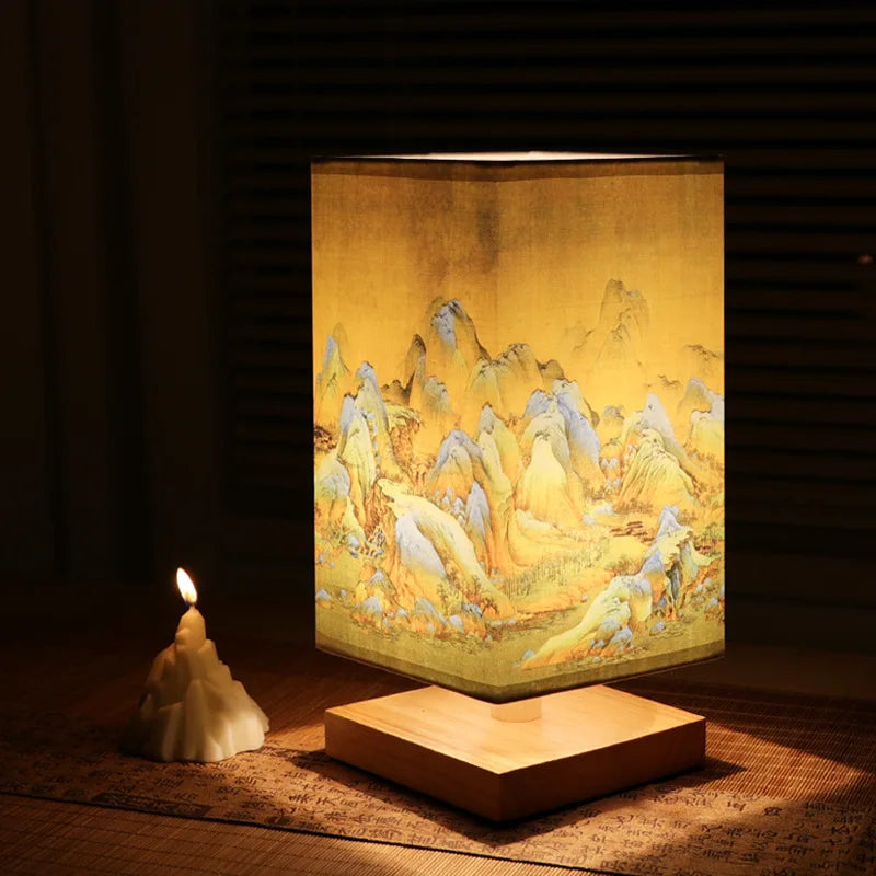 Wooden bedside table lamp with fabric shade and decorative landscape art, warm ambient lighting for bedroom