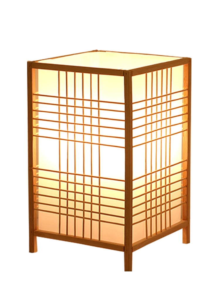 Handwoven bamboo table lamp glowing on a bedside table