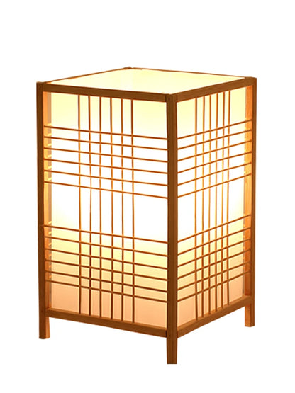 Handwoven bamboo table lamp glowing on a bedside table