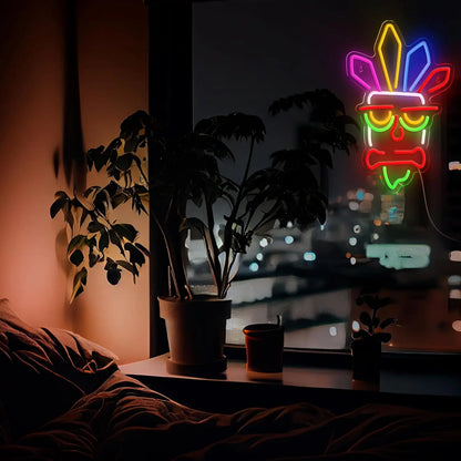 Neon sign with a face design in a dark room with plants and a window view.