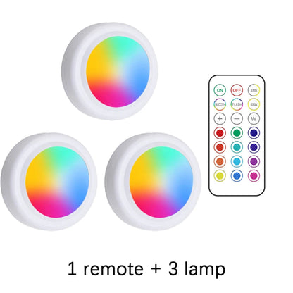 Three RGB LED lights with a remote control on a white background