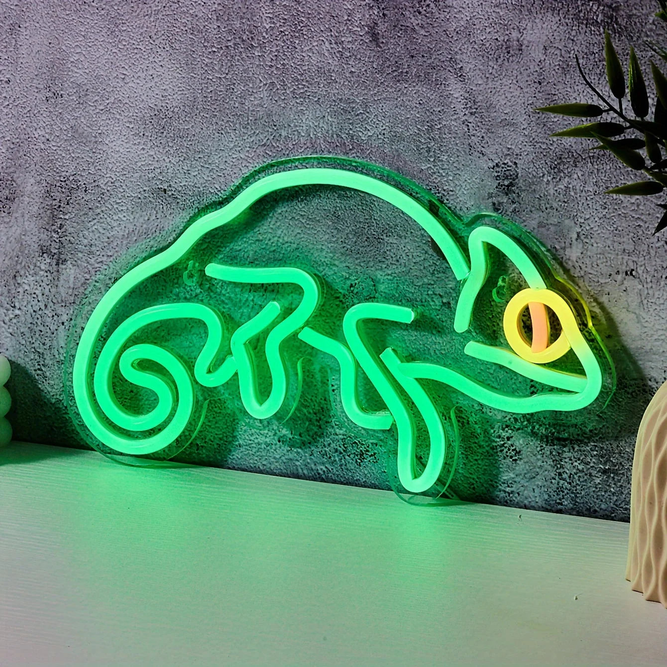 Neon lizard-shaped sign on a textured wall background