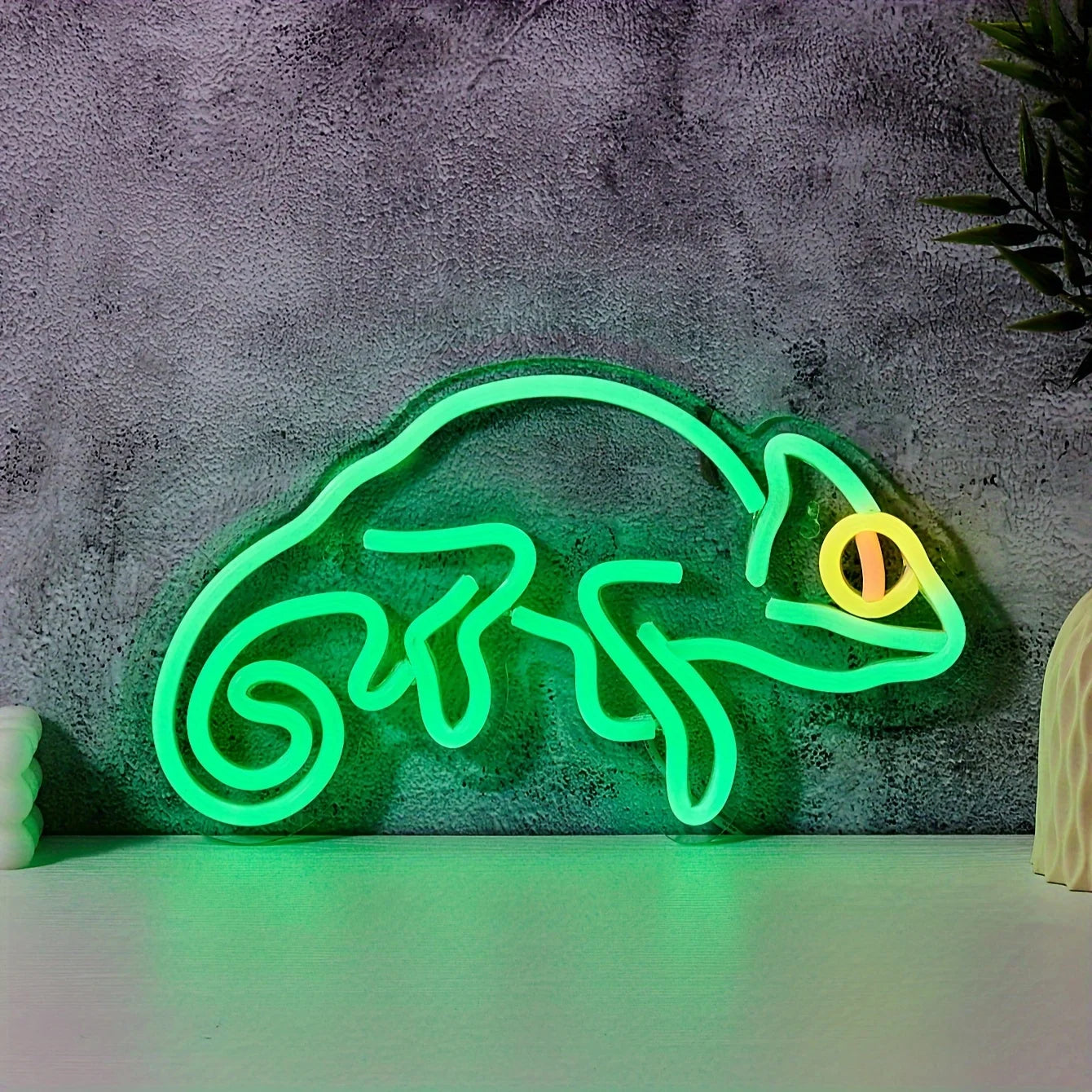 Neon lizard-shaped sign on a textured wall background